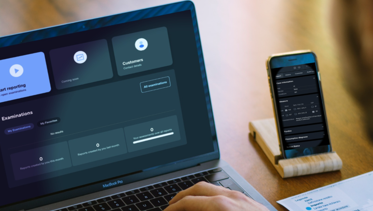 A mobile phone and laptop on a desk, both displaying a part of an app developed for a client.